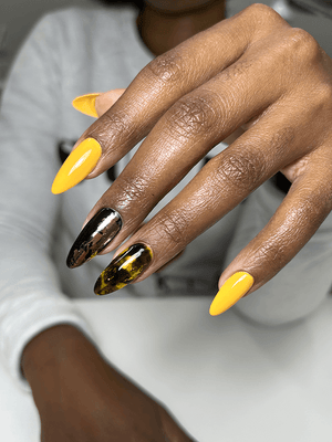 Hand with painted yellow and black long nails